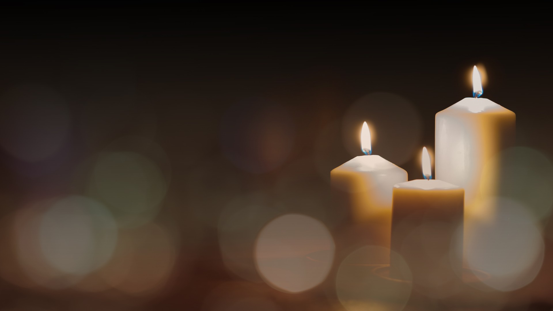 Christmas advent candle light in church with blurry golden bokeh for religious ritual or spiritual zen meditation, peaceful mind and soul, or funeral ceremony